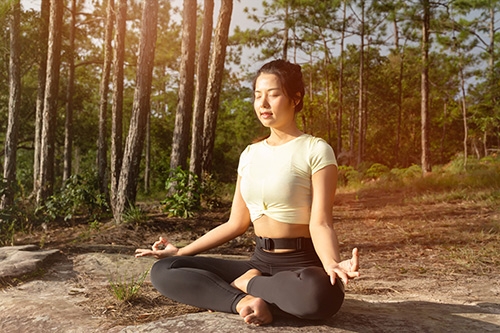 femme en m&eacute;ditation dans la for&ecirc;t